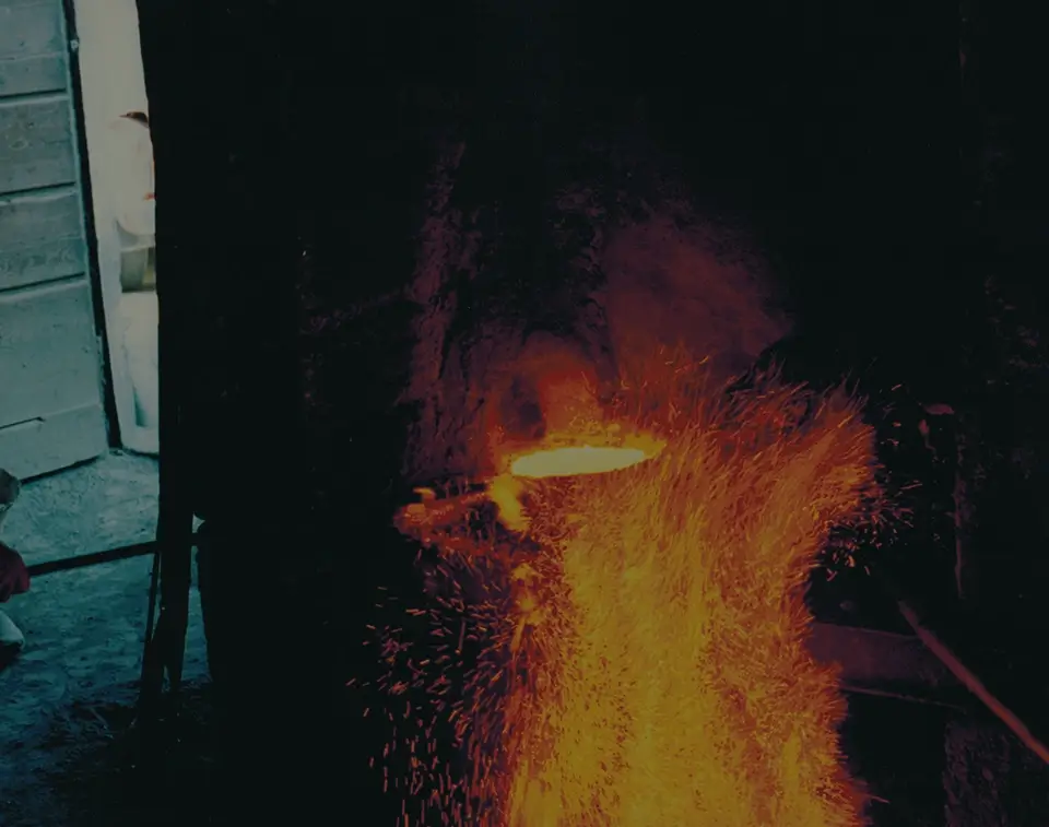 Foto dell'officina con fiamme che scaldano rame nello stampo